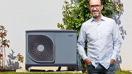 Man staat voor warmtepomp unit in de tuin
