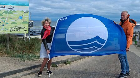 Wethouder Thessa van der Windt en Voorzitter Reddingsvrigade Ruud Cloeck met de Blauwe Vlag 2026